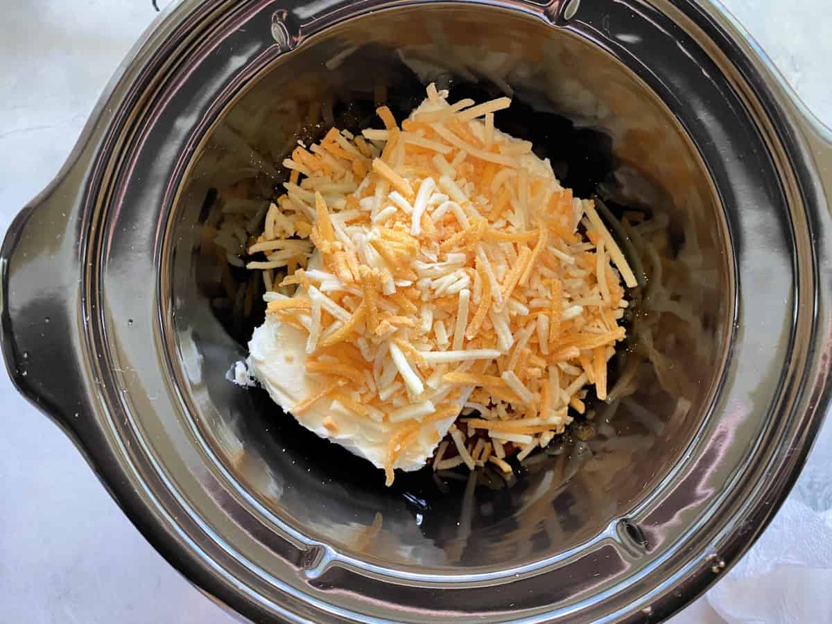 Top view of shredded cheddar in mini slow cooker.