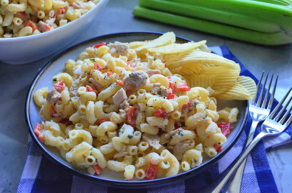 Mac and Tuna Fish Salad on a plate with ruffels potato chips and two forks.