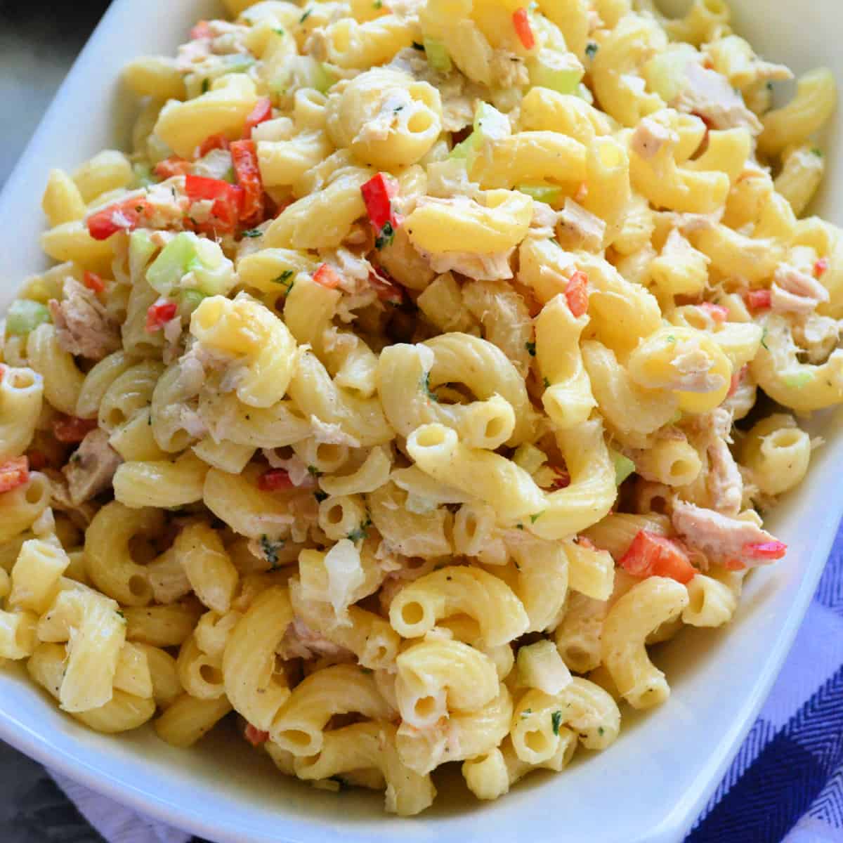 White rectangular bowl with macaroni, tuna, and vegetables.