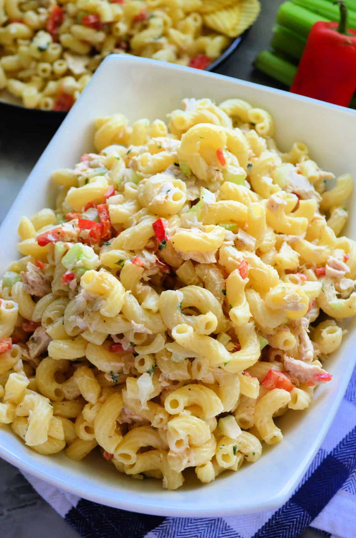 White rectangular bowl with macaroni, tuna, and vegetables.