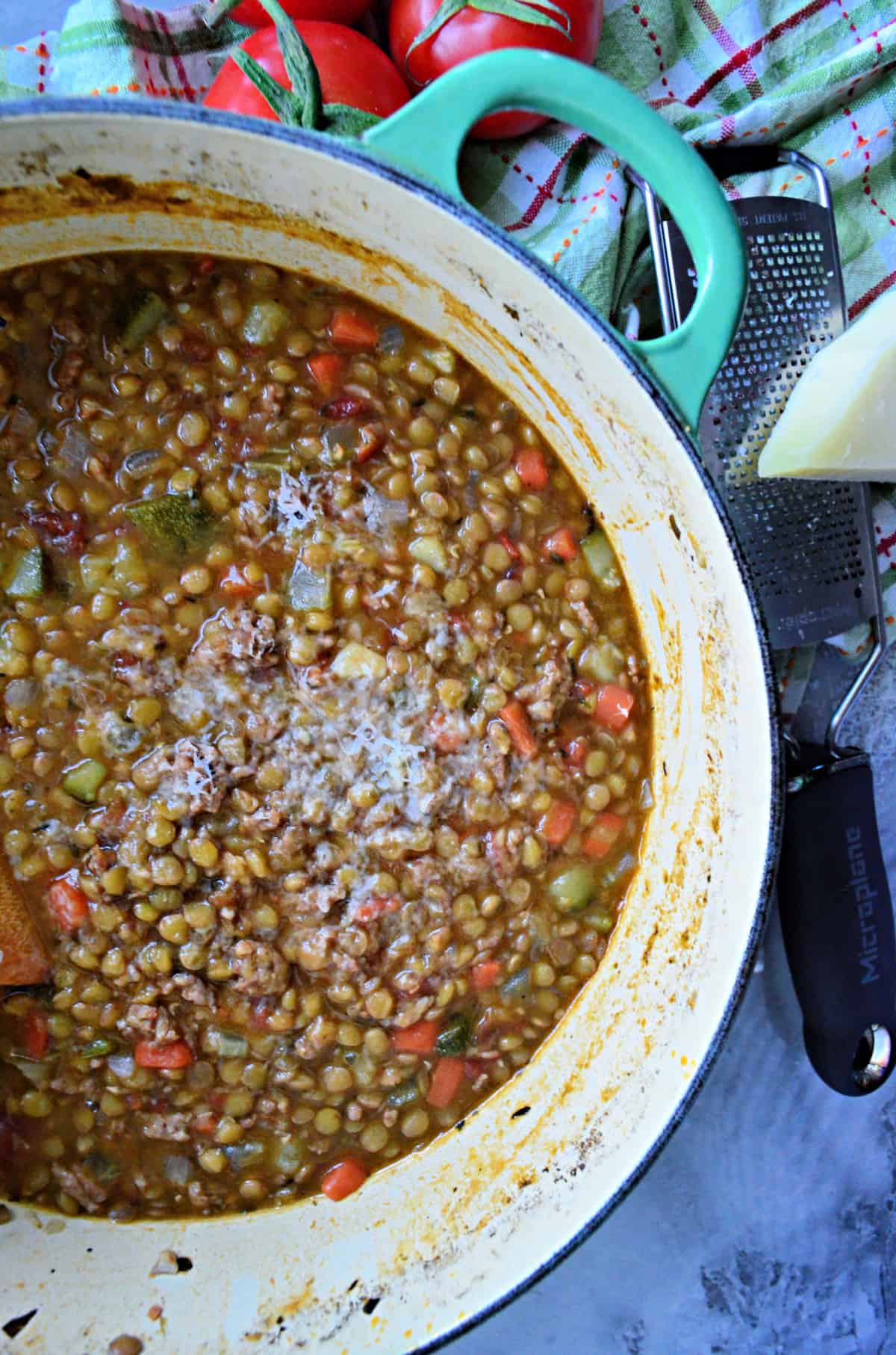 top view of large green cast iron pot full of Sausage Lentil Soup.