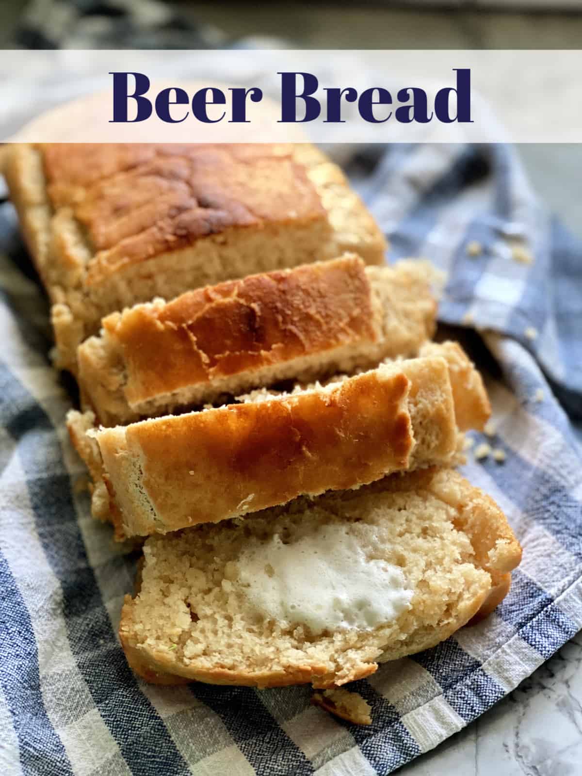 Sliced loaf of Beer Bread resting on tablecloth with title text.