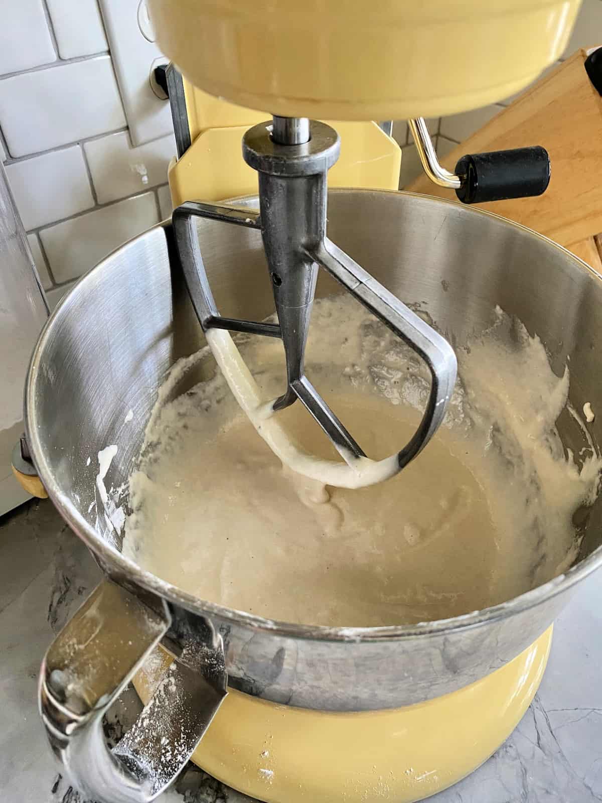 white bread batter in yellow KitchenAid mixer. on countertop.