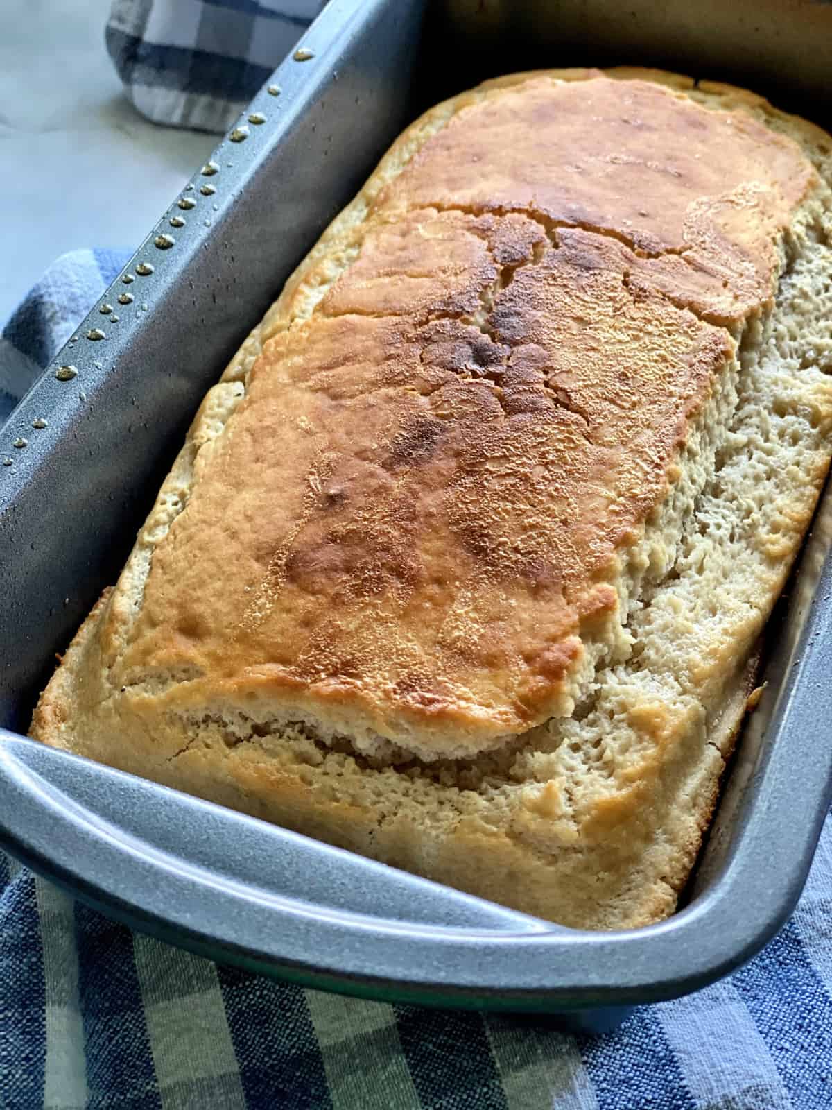 Freshly Baked Golden Brown Beer Bread resting in a metal loaf pan.