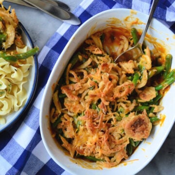 Golden Green Bean Casserole plated next to the remaining contents in the casserole dish.