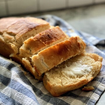 sliced Beer Bread resting on a plaid dish cloth.