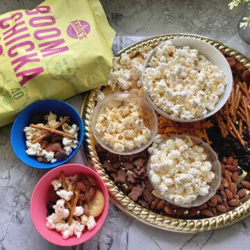 Angie's Boom Chicka Pop Sea Salt Pop Corn bag next to snack board.