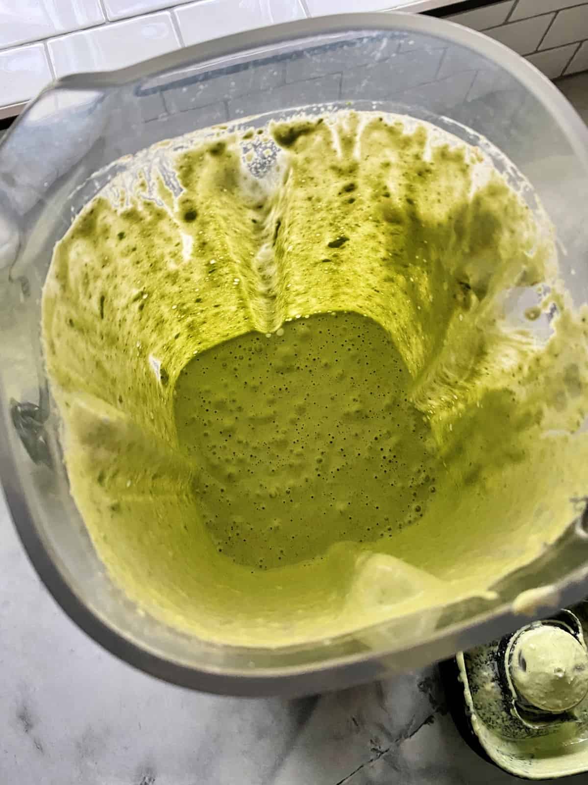 Top view of blended creamy cilantro dressing in blender.
