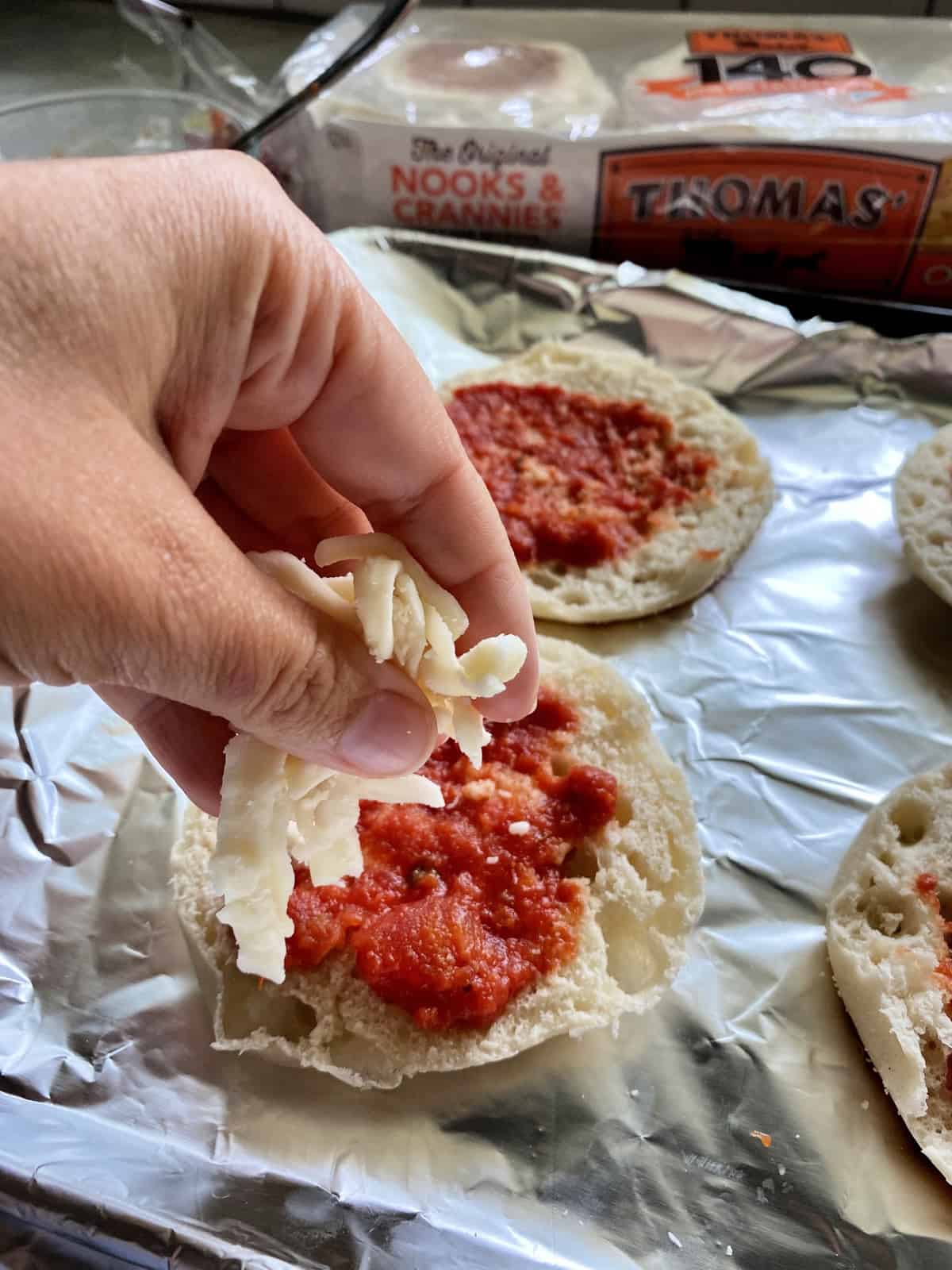 Toaster Oven English Muffin Pizzas topped with sauce and cheese.