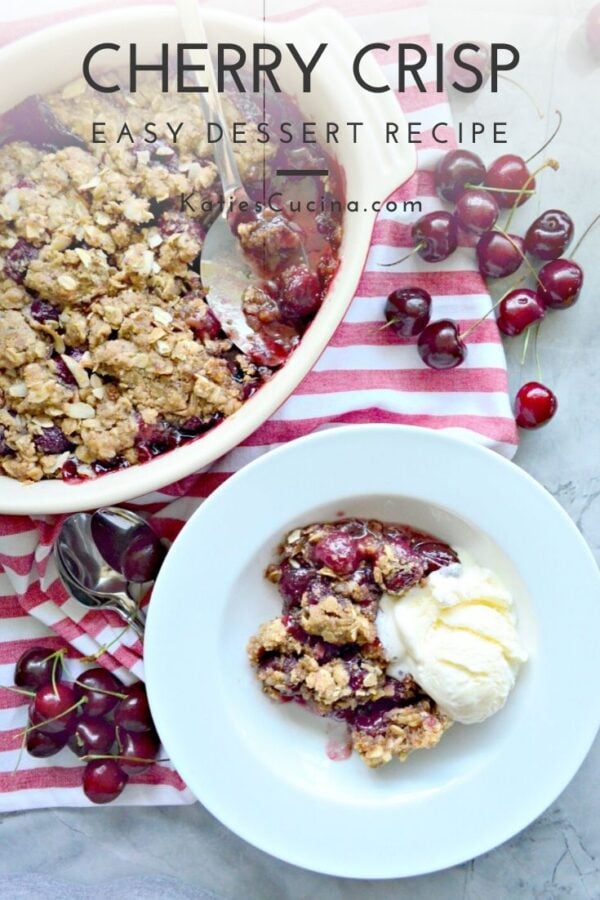 Top view of a half eaten cherry crisp with a white bowl of crisp and ice cream.