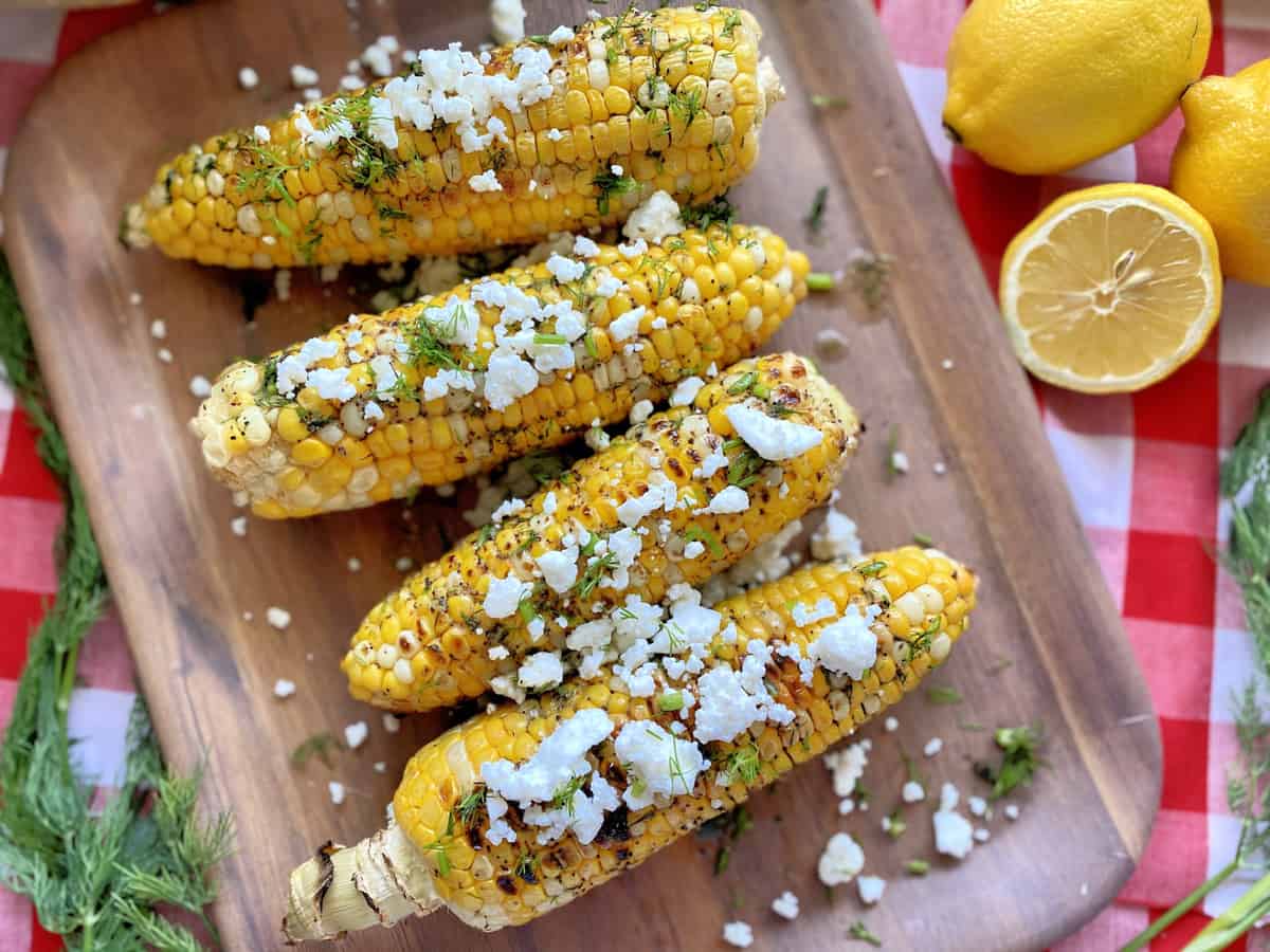 Top view of corn on the cob topped with fresh dill and feta.