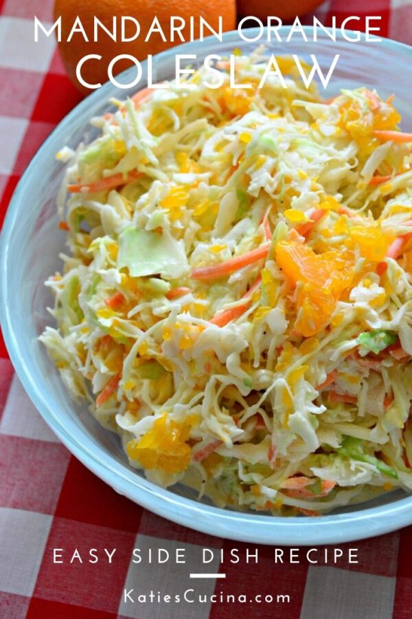 Close up of a top view of coleslaw with oranges in a blue bowl with text.