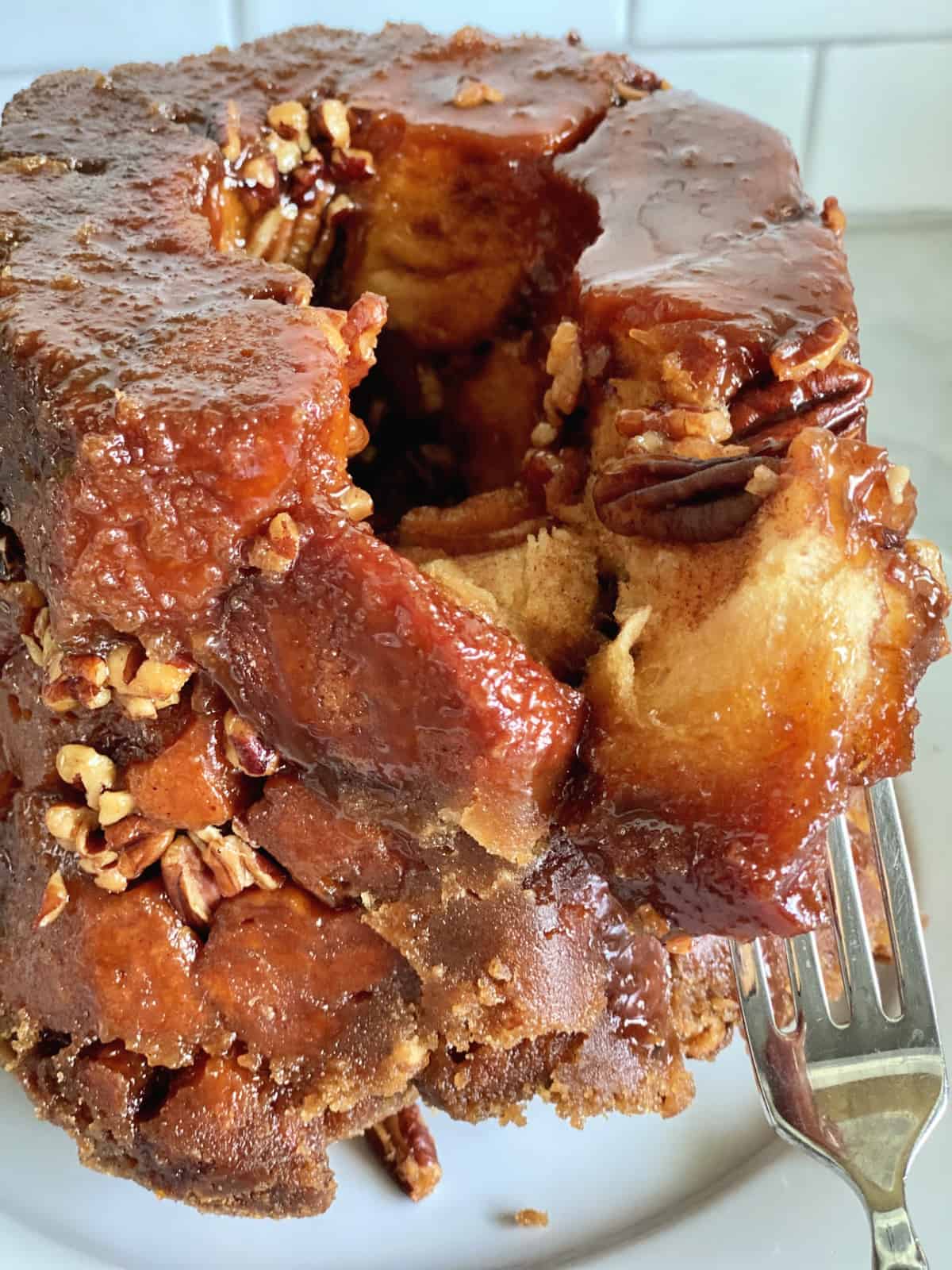 Sticky brown sugar dough pulled apart with a fork with pecans nestled throughout. 