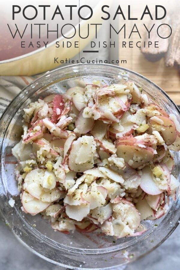 Top view of thinly sliced potato salad in glass bowl with text on imgage.