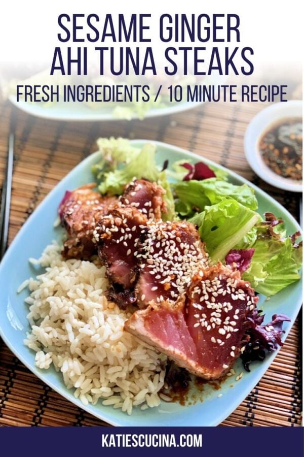 Top view of blue plate with sliced tuna with seasame seeds on white rice and salad.