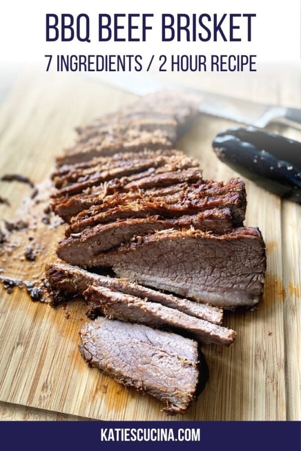 Sliced beef on a wood cutting board with tongs and a knife in the background.