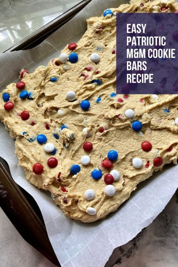 Sheet pan with cookie dough and Red, White & Blue M&M's on parchment paper.