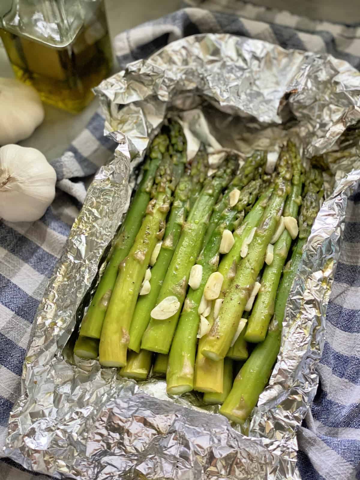 Overhead view of asparagus and sliced garlic nestled in a foil pouch.