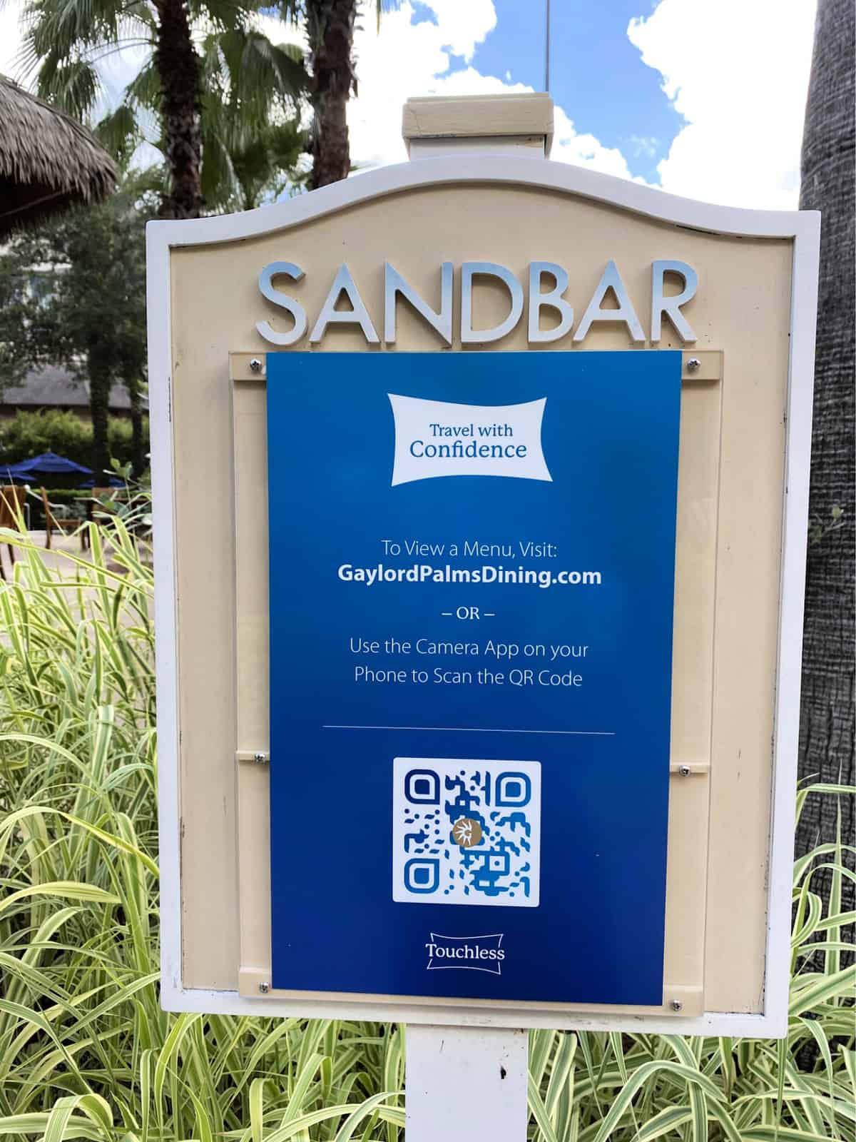 Sandbar travel with confidence sign that has a dining menu qr code.