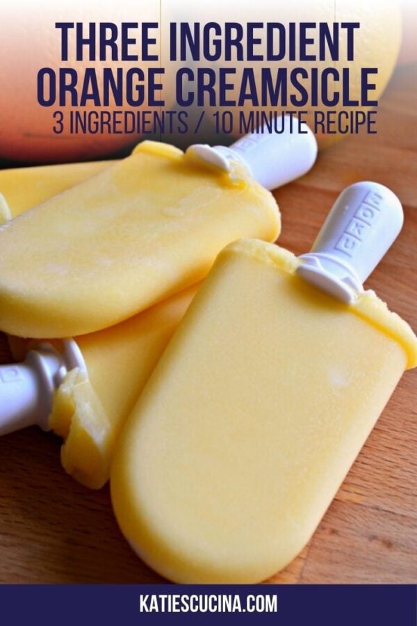 Stack of four orange popsicles on a wood counter with text on image for Pinterest.