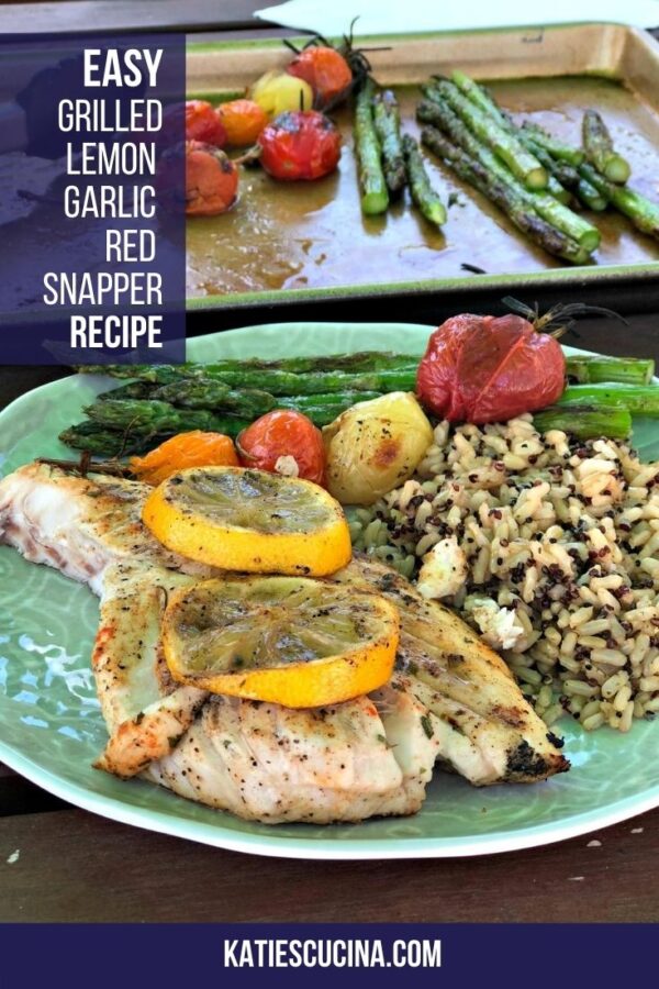 Fish with lemon on a green plate with rice and veggies.