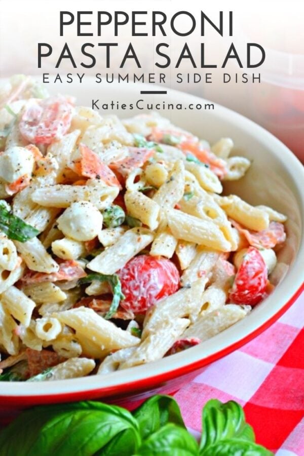 Creamy penne pasta salad with tomatoes and basil text on image for Pinterest.