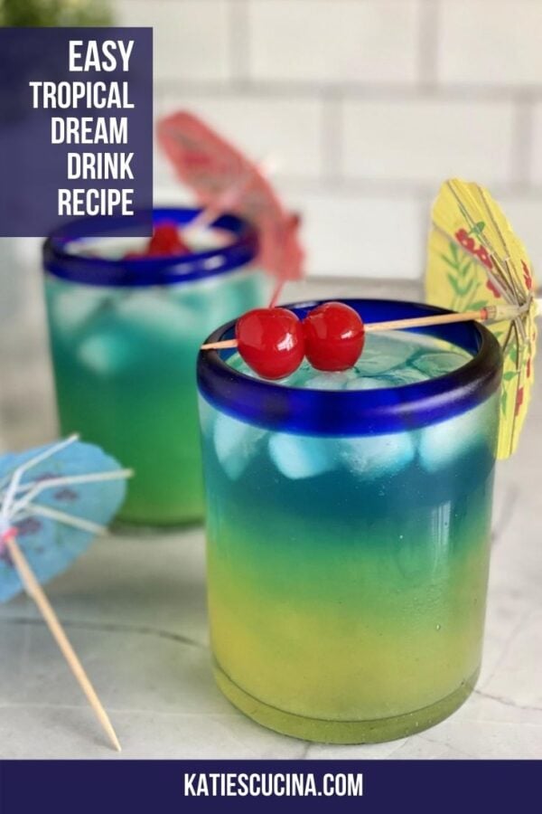 Two yellow, green, blue layered drinks with 2 maraschino cherries on top.