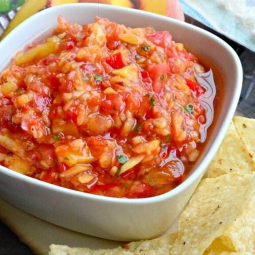 Tray of chips with square bowl on peach salsa with text on image for Pinterest.