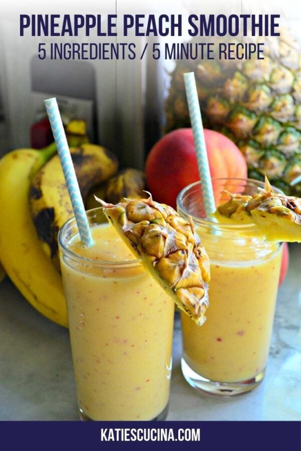 Two yellow smoothies in a clear tall glass with a blue straw and pineapple on the rim.