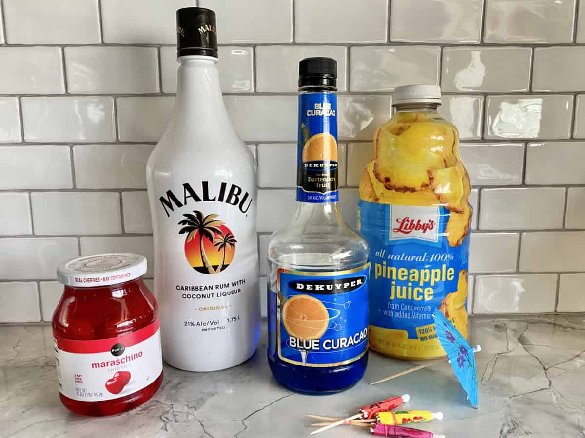 Ingredients; Maraschino cherries in a jar, Malibu rum, Blue Curacao, Pineapple Juice and paper umbrellas.