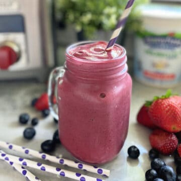 Close up of a purple smoothie is a mason jar style glass.