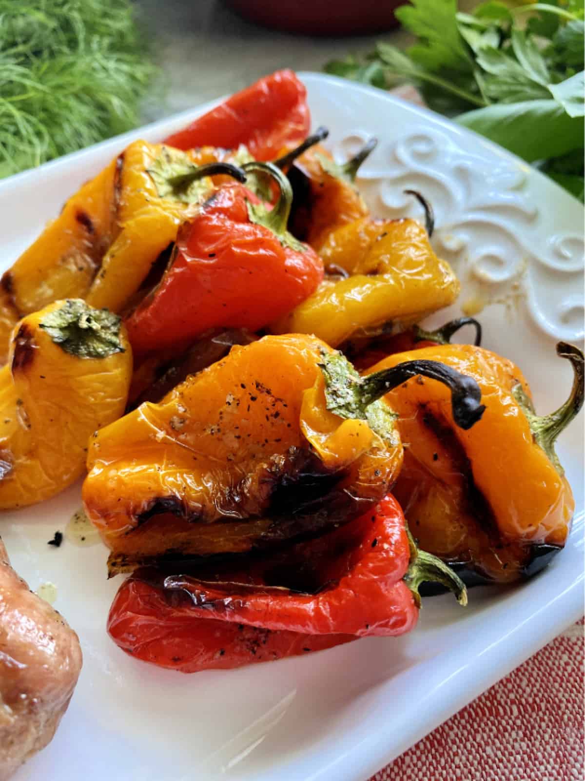 White platter of cooked and charred mini bell peppers.