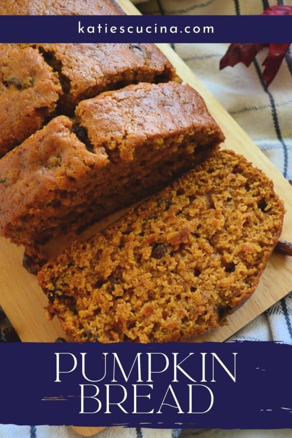 Top view of pumpkin loaf with two slices on a wood board with text on image.