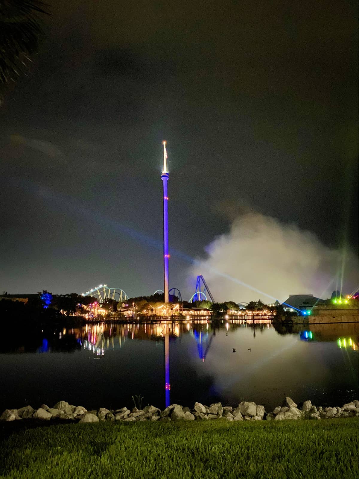Nightime sky of SeaWorld Orlando over looking a pond with coasters in the distance.