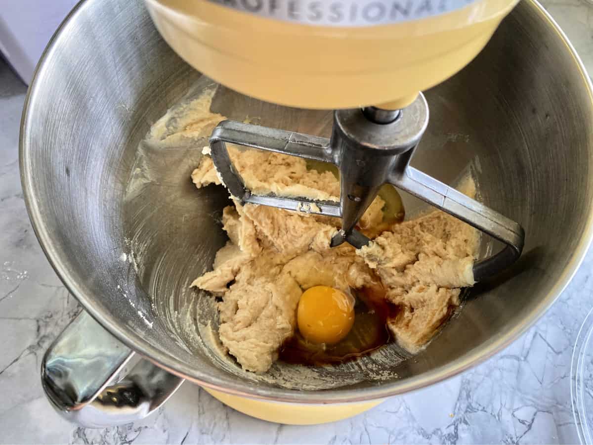 Top view of stand mixer with a flat paddle with creamed sugar and egg.