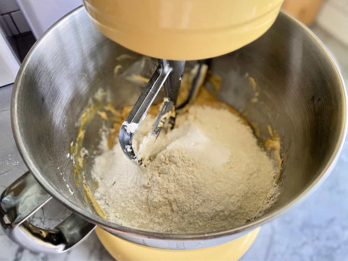 Top view of a mixing bowl with flour and a paddle attchement.