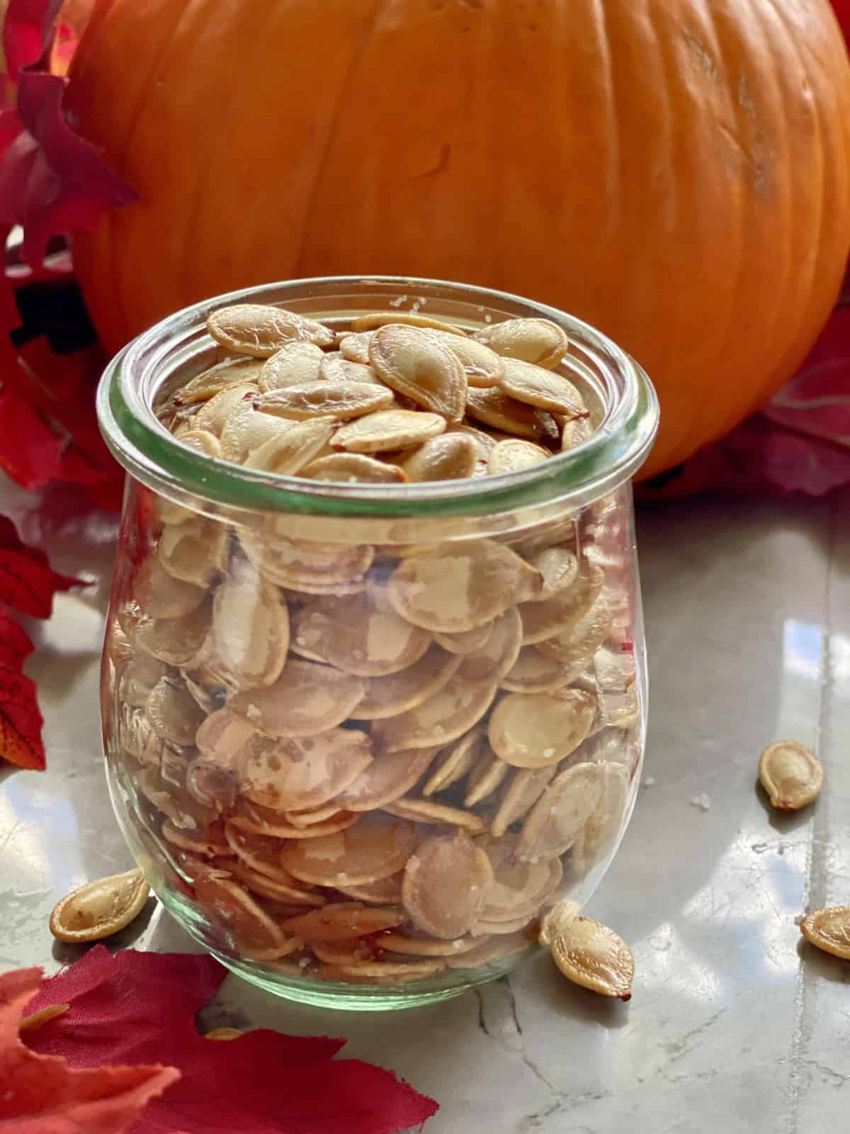 Glass jar filled with roasted pumpkin seeds.