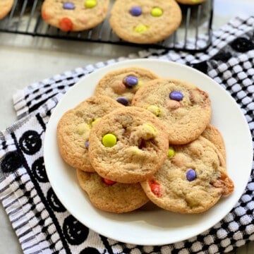 White plate filled with cookies stacked on top of each other with a black and white checkered cloth.