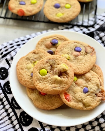 White plate filled with cookies stacked on top of each other with a black and white checkered cloth.