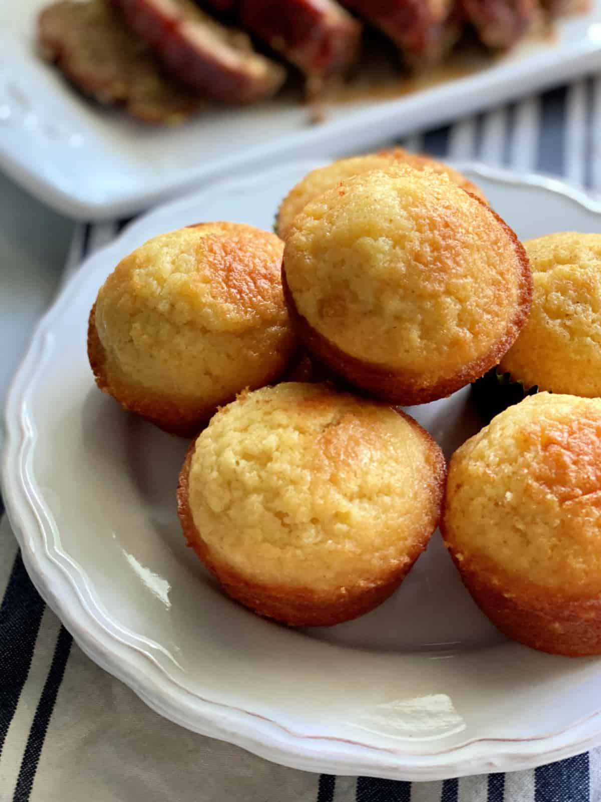 Up close view of muffins stacked on a white plate.