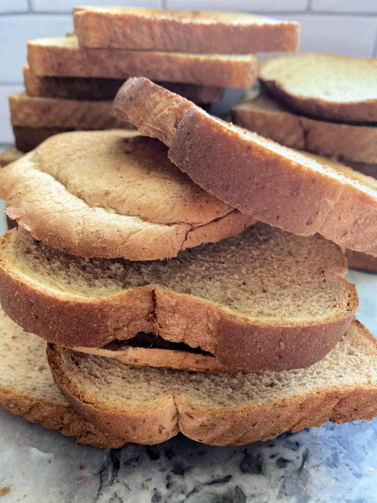 A stack of toasted sliced bread on a marble countertop.