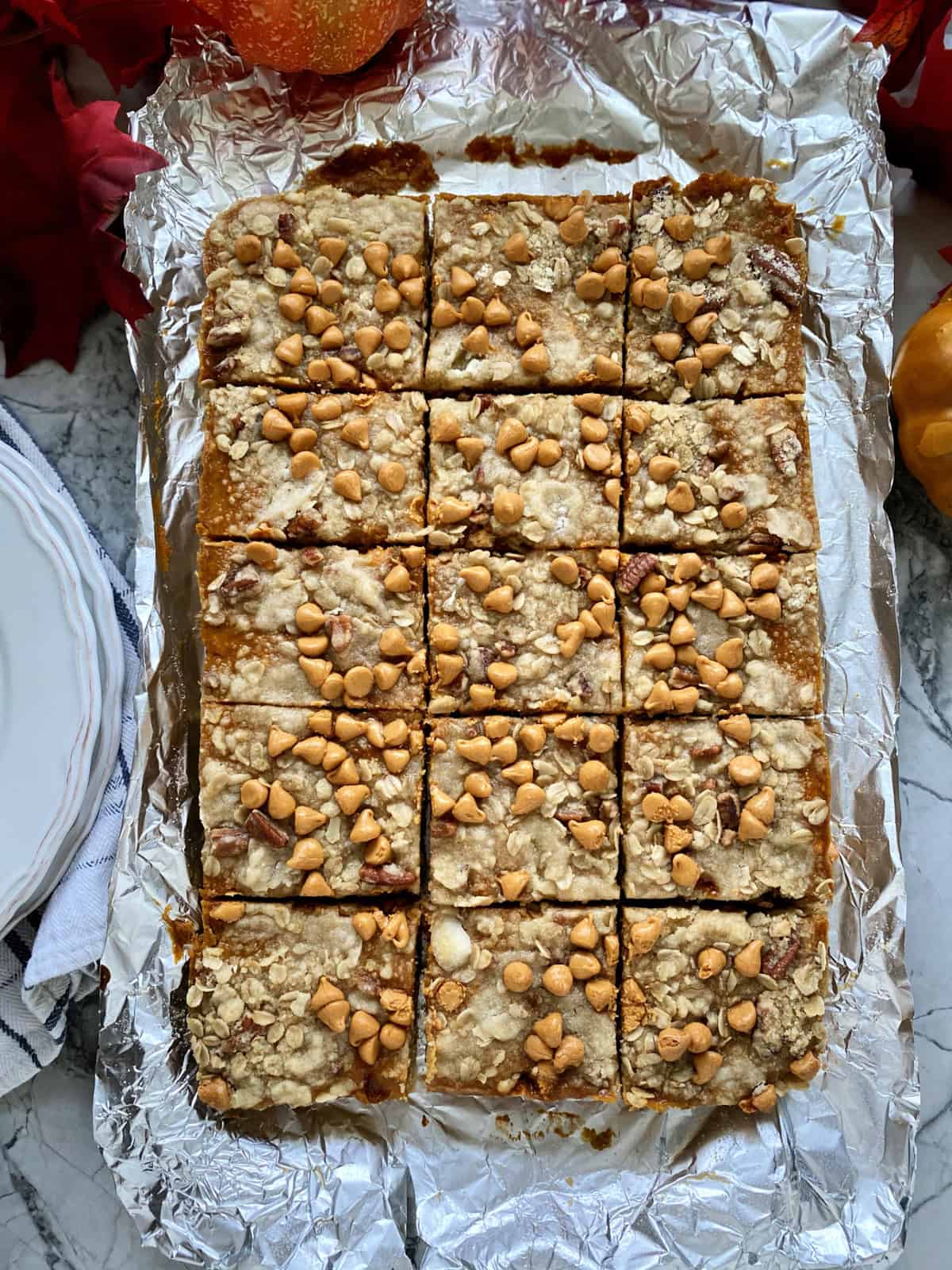 15 pumpkin pie bars in a shape of a rectangle sitting on aluminum foil.