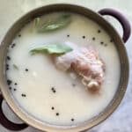 Top view of sage leaves in a buttermilk brine with raw turkey.