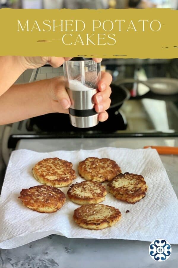 Female hand grinding salt on top of potato cakes on a paper towel lined plate with text on image for Pinterest.