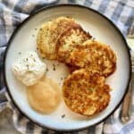 Top view of a plate of mashed potato cakes on a plate with toppings.