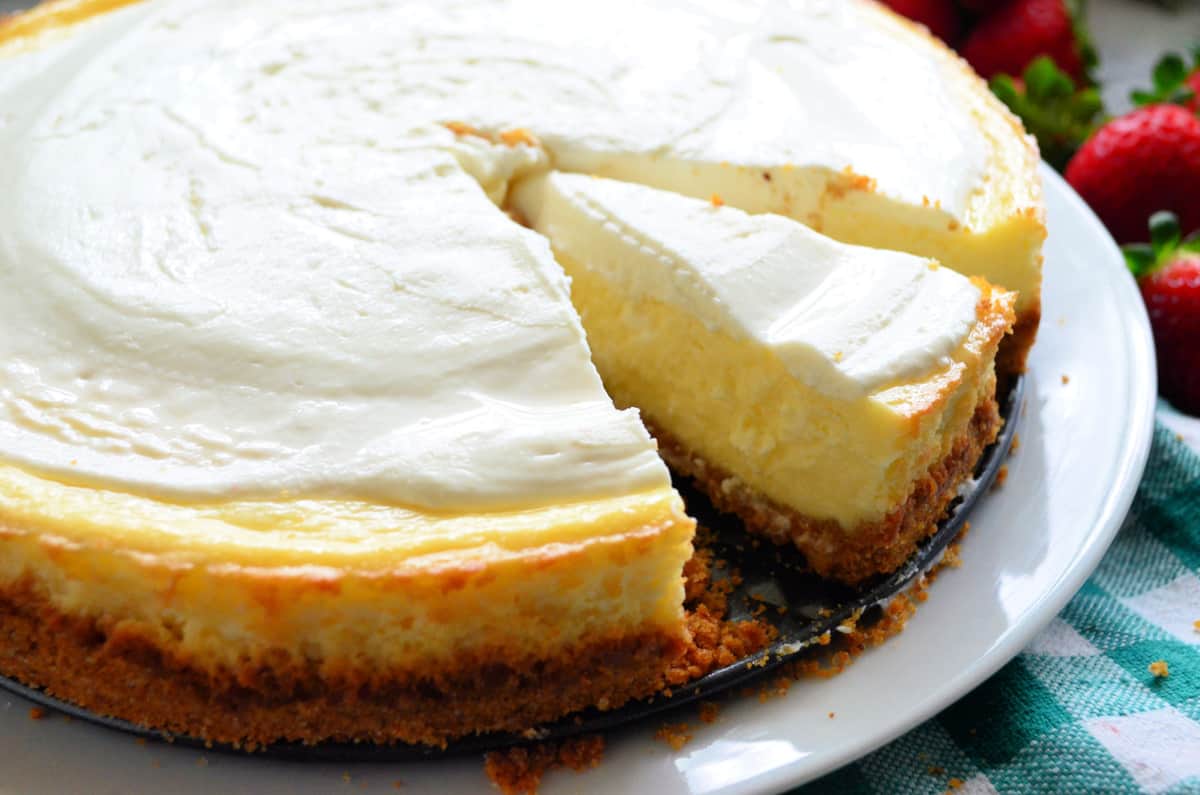 Close up of a cheesecake with slices taken out.