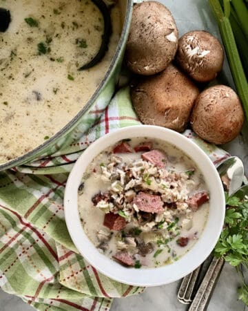 Top view of a pot of soup plus a bowl of sausage and rice soup.