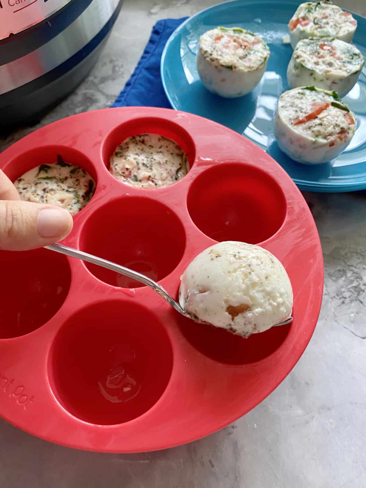 Spoon removing egg bite from a silicone mould.