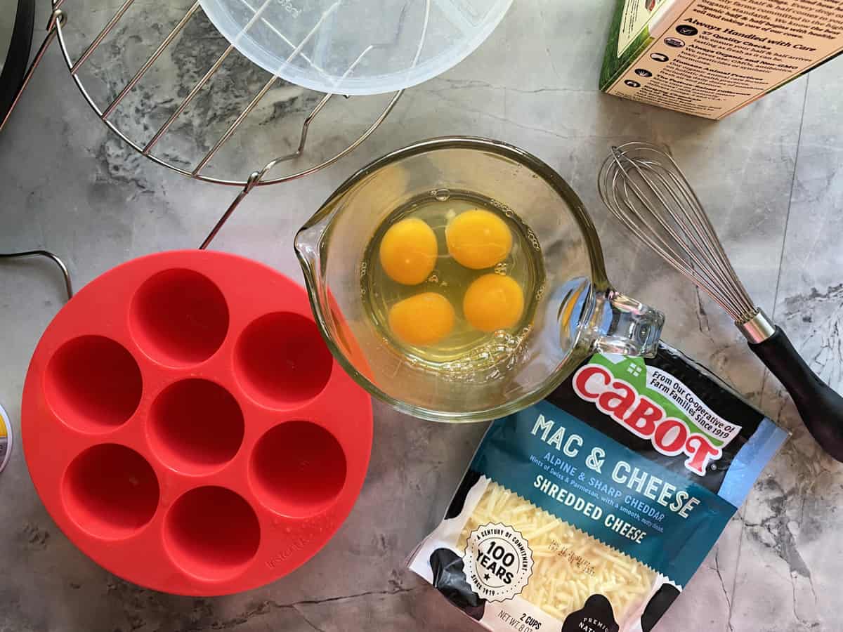 Instant Pot egg mold with four eggs in a glass measuring cup.