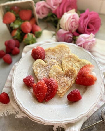 Top view of heart pancakes on a white plate with heart shaped pancakes.